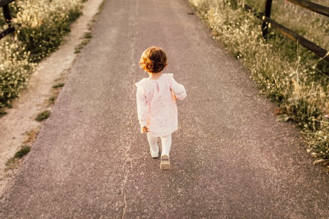Little girl walking on road chronic lower back pain